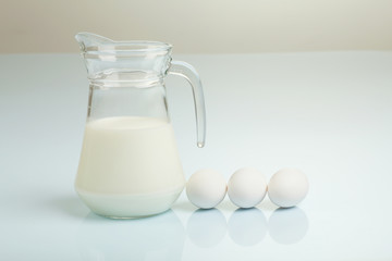 Milk in a glass jar and eggs