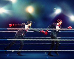 Two young businessman boxing