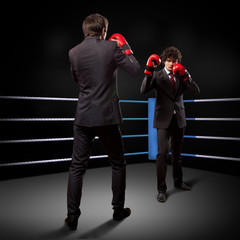 Two young businessman boxing