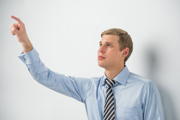 Young positive business man touching virtual button. Editable im © Milles Studio