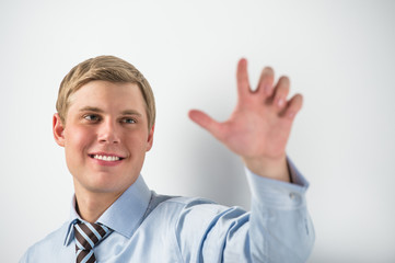 Young positive business man touching virtual button. Editable im © Milles Studio