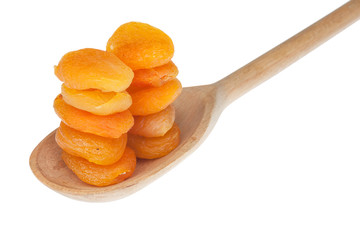 Dried apricots in a wooden spoon