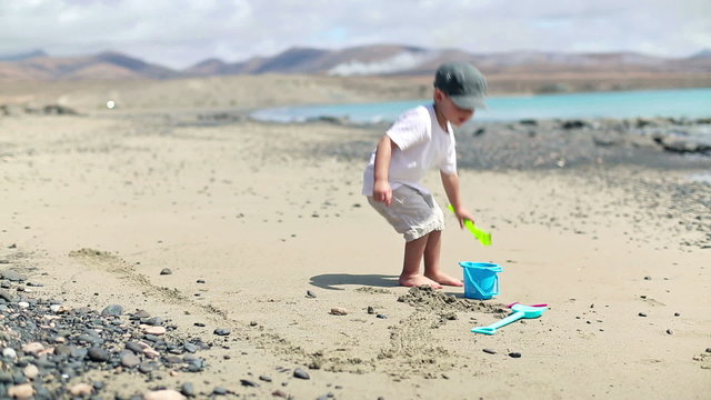 Little boy with mother playing on the beach
