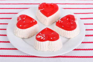Cakes in the shape of a heart with coconut on a white plate