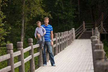 Fototapeta na wymiar Father and son near fence in park