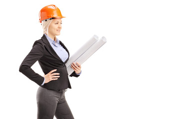 A female architect wearing an orange helmet and holding a bluepr