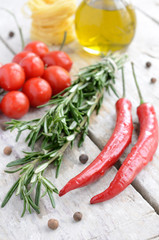 Fototapeta na wymiar Italian ingredients - rosemary, olive oil, chilli, tomatoes