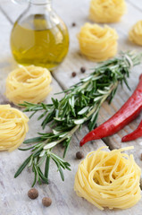 Raw tagliolini nest with rosemary, red chilli and allspice on wo