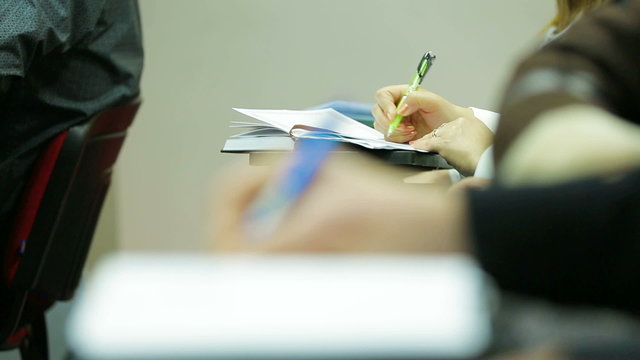 Audience of a symposium taking notes. Close-up