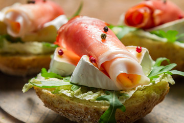 Closeup of fresh sandwiches with parma ham and brie cheese