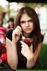 Young woman with dessert at sidewalk cafe