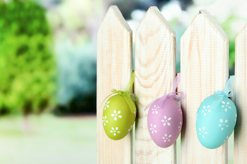 Art Easter background with eggs hanging on fence