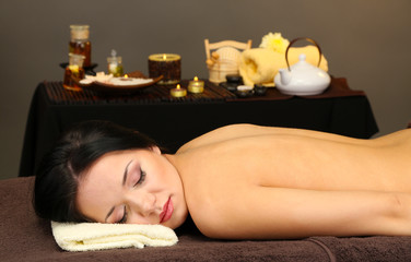 Beautiful young woman in spa salon with spa stones,