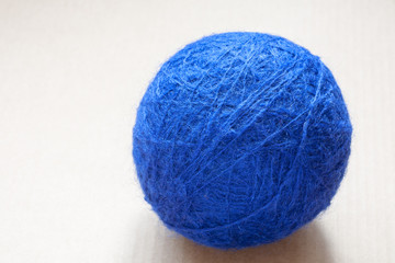blue wool yarn skein on cardboard background