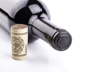 botella de vino tinto tumbada, sobre fondo blanco