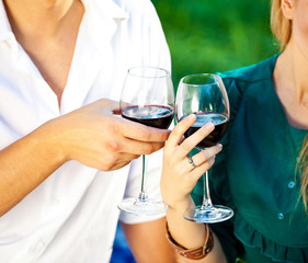 couple holding a glass of red wine in the garden
