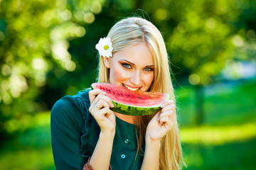 attractive blonde woman holding watermelon outdoor