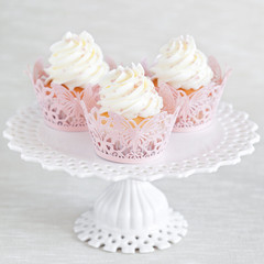 Obraz na płótnie Canvas Cupcakes with vanilla cream on cake stand, selective focus