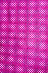 wrinkled purple cloth with a white dot