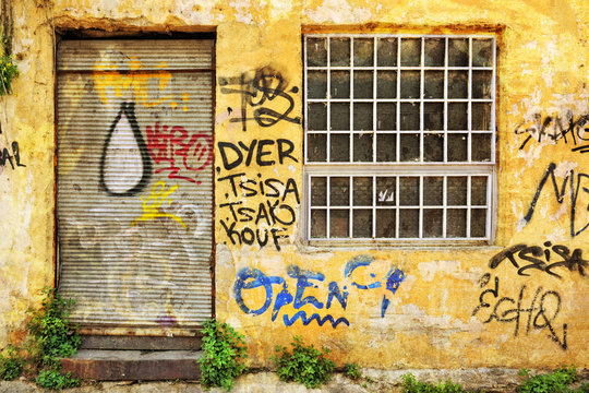 Abandoned shop exterior covered with graffiti in Athens