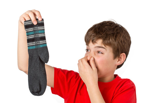 Junge mit stinkenden Socken h&auml;lt sich die Nase zu