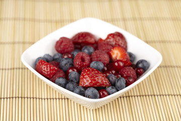 Obstsalat in einer Schale auf einem Strohset