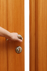 Hand opening the door. Vertical format
