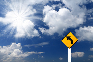 Direction sign- left turn sign pointing to rays of light on blue