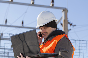 Electrician with PC and cell phone