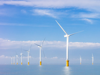 wind power generators farm at sea with white clouds and blue sky