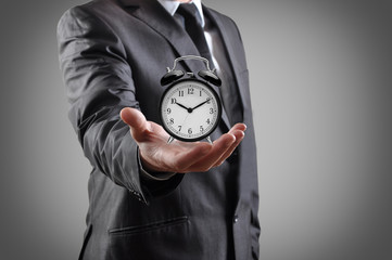 businessman with an alarm clock in a hand.
