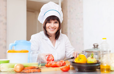   female cook with vegetables on cutting board