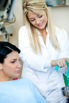 Smiling dentist assistant with patient
