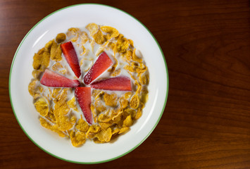Strawberry and cereal with milk for breakfast.