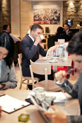 Young businessman sitting at table in cafe