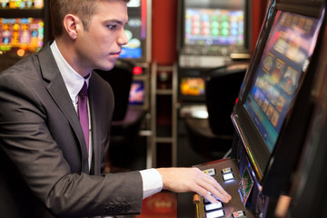 Men gambling in the casino on slot machines