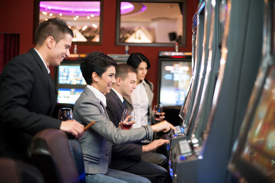 young people gambling in the casino on slot machines