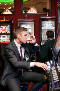 handsome man playing the slot machine
