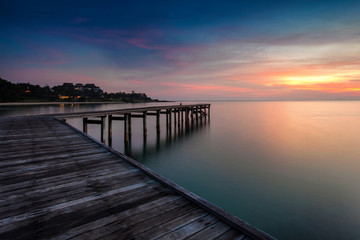 sunrise with dramatic sky and a jetty