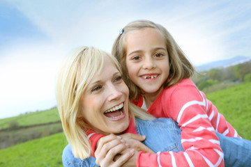 Woman holding daughter on her back © goodluz
