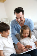 Fototapeta premium Children with daddy at home using digital tablet