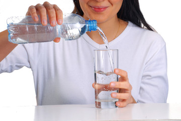 Mujer sirviendo agua potable en un vaso,agua mineral.