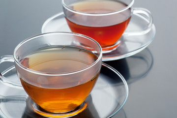 Transparent cup with green and black tea