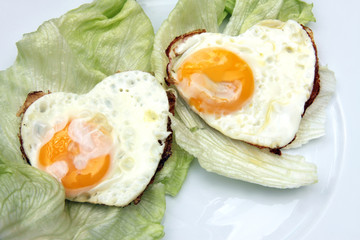 Herzförmiges Spiegelei auf Salat