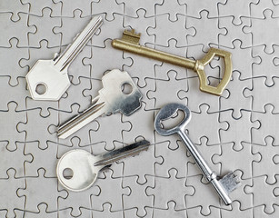 Fototapeta premium Keys of different types of puzzles on a close-up of gold and sil