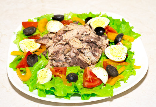 Delicious salad with tuna, tomatoes, eggs, olives and peppers