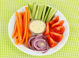 Assorted raw vegetables sticks in plate on table close up