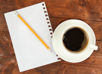 Cup of coffee on worktable covered with documents close up