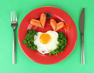 Sausages in form of hearts, scrambled eggs and parsley,