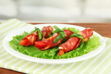 Salami rolls on white plate on bright background